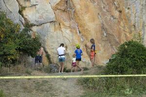 Crimea, Ukraine, July 28, 2021 - Extreme, rock climber on a sheer gray-red rock in the Crimean mountains. photo