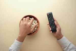 high angle view of popcorn and Tv remote on table photo