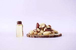 brazilian nut dropping in a bowl and oil in a small bottle photo