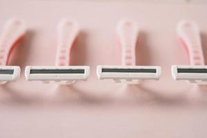 maquinilla de afeitar rosa sobre fondo rosa de cerca. foto