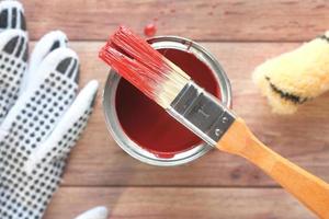 top view of a paint brush , gloves and paint on table photo