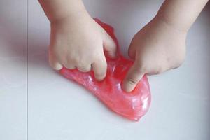 child Hand holding slime on tiles floor top view , photo