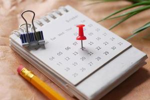 deadline concept with push pin on calendar date close up photo