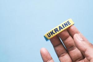 Hand with blue and yellow wristband , colors of flag of Ukraine. photo