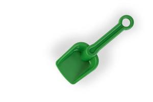 Children's green plastic shovel for sandbox or beach on a white background. photo