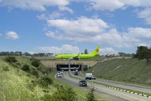 Simferopol airport, Ukraine, July 20, 2021 - Green commercial passenger jet airliner Airbus A319 of S7 Airlines, Siberia Airlines, on the airport apron before takeoff over the car tunnel. photo