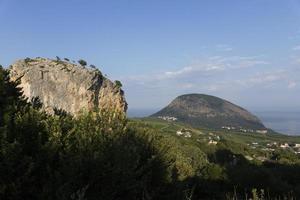 piedra roja rocosa contra el telón de fondo de la montaña medved en la costa sur del mar negro. paisaje foto
