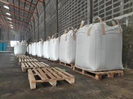 Large jumbo hemp sack White, packed with chemical fertilizer, rice, sugar, placed on a wooden pallet waiting to be delivered to the customer photo