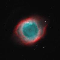 nebulosa de hélice fotografiada a través de los telescopios robóticos remotos del telescopio en vivo en filtros de banda estrecha hoo, nebulosidad roja y cian, nebulosa planetaria en un cielo oscuro foto