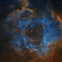 nebulosa de roseta fotografiada a través de los telescopios robóticos remotos del telescopio en vivo en filtros de banda estrecha sho, nebulosidad azul y amarilla en la paleta hubble de un gran objeto espacial foto