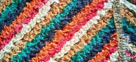 textura de alfombra tejida recta multicolor variada. material textil de línea vertical de grunge fino borroso. alfombra rizada efecto tela alfombra. foto