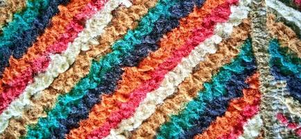 Variegated multicolor straight woven carpet texture. Fuzzy thin grunge vertical line textile material. Curly carpet rug fabric effect. photo