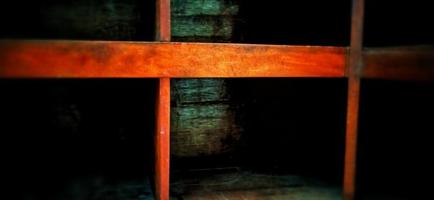 An old and dull red orange wooden locker under a dim background. photo