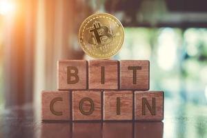 A group wooden cubes on table with word Bitcoin on it background. photo