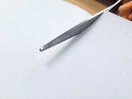 tijeras cortando el papel blanco, copie el espacio. foto
