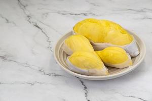 durian fresco en envases en plato durian rey de la fruta tailandesa. famosa fruta tropical. sabor dulce y cremoso. foto