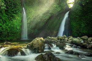 hermosa cascada en la luz mroning en el bosque foto