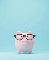 Piggy bank with glasses Saving money and Study abroad concept 3D render photo