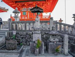 Japanese stone statue in front of red orange templet in japan. photo