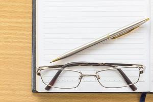 Notebook open blank page and Eyeglasses photo