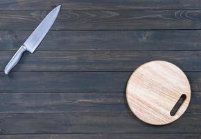 kitchen knife and wooden round empty cutting board
