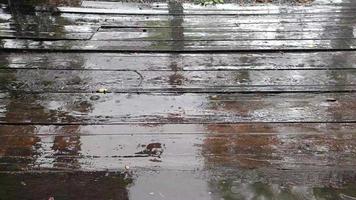 gotas de lluvia cayendo sobre el suelo de tablones de madera marrón video