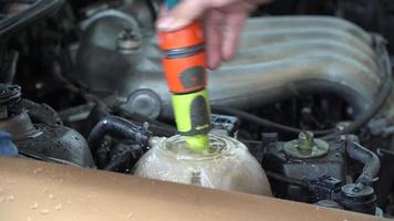 aggiungere acqua al radiatore dell'auto sta bollendo. video