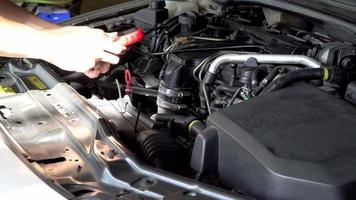 il meccanico sta utilizzando un lettore di codici diagnostici per auto. Lettura degli errori del computer dell'auto utilizzando un dispositivo mobile. video