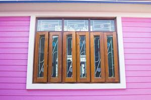 las ventanas de madera y vidrio y las paredes rosadas de la casa son de yeso que se usa popularmente para construir casas en estos días. es una casa de estilo moderno y se está volviendo popular para reemplazar la madera real. foto