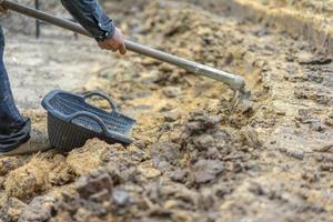 el jardinero cava el suelo con su equipo para jardinería y prepara la tierra para la plantación. foto