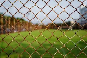 Rust steel net with blur football field. photo