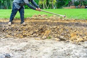 el jardinero cava el suelo con su equipo para jardinería y prepara la tierra para la plantación. foto