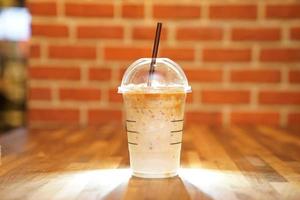 Take away Latte with Brick background on the wood table photo