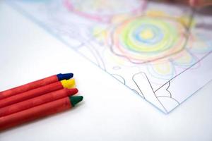 little girl plays and learns to coloring Crayon on the paper in the ice-cream restaurant., Bangkok, Thailand. photo