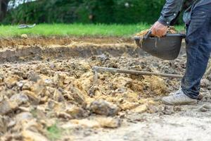 el jardinero cava el suelo con su equipo para jardinería y prepara la tierra para la plantación. foto