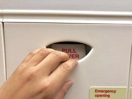 Hand on pull over hole for emergency door on plane photo