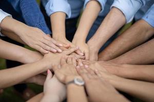 cerca de los asiáticos se toman de la mano en medio de su grupo, amigo con un montón de mano mostrando el amor y la comunidad de buenos amigos. foto