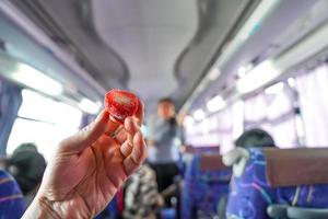 Strawberry with vanilla ice cream inside are held by man hand in the bus. photo