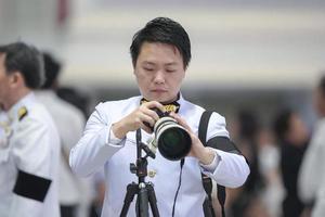 Professional cameraman holding the mirrorless camera with tele len in front of blur crowd background. photo