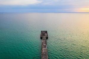 The jetty in the sea with the horizontal sea line by minimal drone photo shooting style in twilight time. Thailand.