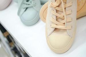 Pastel sneakers on display shelf for sales at sports shop in department store. photo