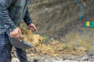 el jardinero cava el suelo con su equipo para jardinería y prepara la tierra para la plantación. foto