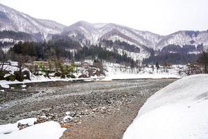 Villages of Shirakawago and Gokayama are one of Japan's UNESCO World Heritage Sites. Farm house in the village and mountain behind. photo