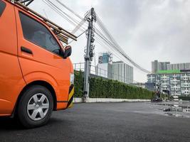 Private company electric orange van parking at the outdoor parking waiting for electric services. photo