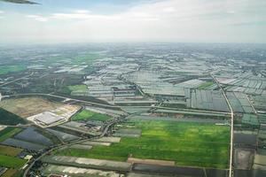 la vista del campo verde y la granja y el centro de la ciudad en medio de tailandia. se disparó desde un avión a reacción. foto