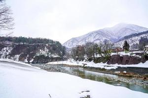 los pueblos de shirakawago y gokayama son uno de los sitios del patrimonio mundial de la unesco de japón. casa de campo en el pueblo y montaña detras. foto