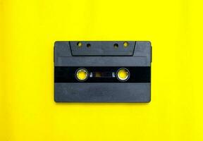 Old compact cassette tape on yellow background photo