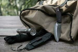 un cuchillo con equipo para sobrevivir en el bosque foto