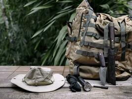 A knife with equipment for survival in the forest  on an old wooden floor photo