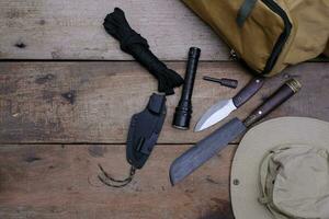 un cuchillo con equipo para sobrevivir en el bosque en un viejo piso de madera foto